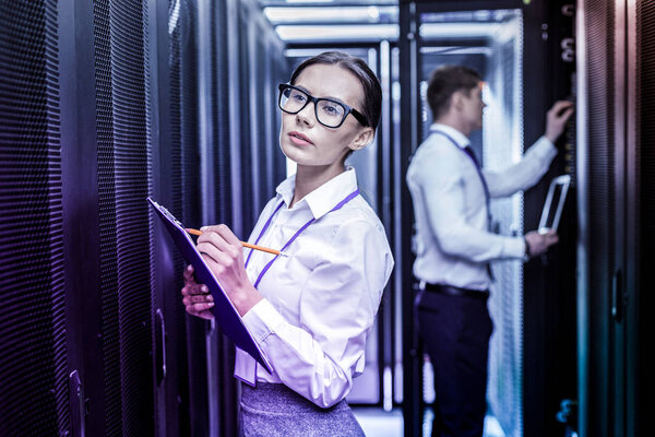 Умная серьезная женщина делает заметки во время работы
