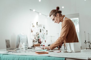 Kahverengi bir giysi konsantre arıyorsunuz bir moda stüdyosundan profesyonel tasarımcı