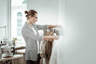 Sarışın yakışıklı moda tasarımcısı çizgili ceket modelleri göstermek için seçme