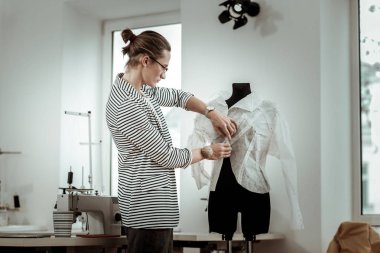 Yakışıklı genç moda terzi bir atölyede meşgul seyir çizgili ceket