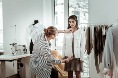 Uzun boylu trendy moda tasarımcısı uzun saçlı yeni bir model ile çalışma