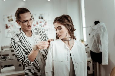 Birlikte çalışıyor. Parlak makyaj moda tasarımcısı ile çalışma büyük küpeler ile gülen esmer kız
