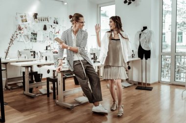 Olumlu gülümseyen bir bej elbise inanılmaz genç uzun saçlı modelinde