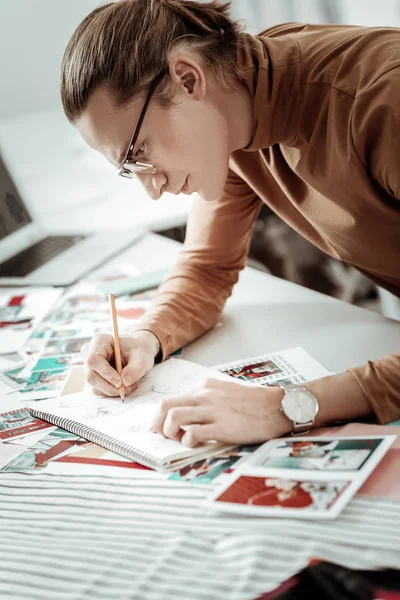 Молодий дизайнер зі школи моди з годинником на руці малюнок ескізів нових суконь — стокове фото