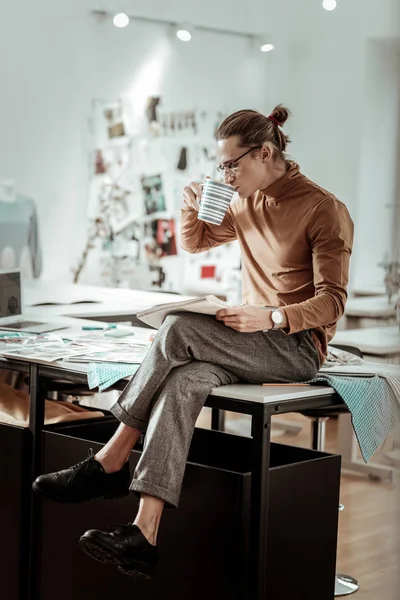 Alto joven diseñador de la escuela de moda en zapatos negros con café — Foto de Stock