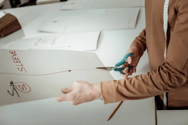 Professionele ontwerper in een bruin kledingstuk werken op een mouw-curve — Stockfoto