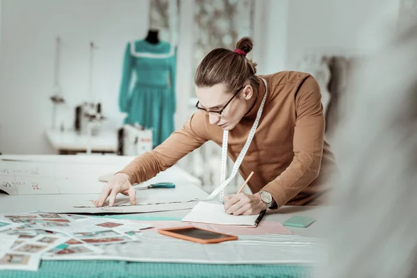 Alta diseñadora joven de pelo largo de una escuela de moda con gafas que parecen ocupadas —  Fotos de Stock