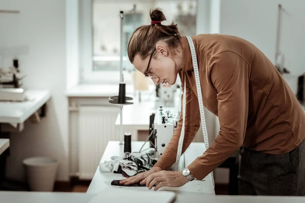 Vestidor alto joven en gafas que trabajan con tela para el vestido —  Fotos de Stock