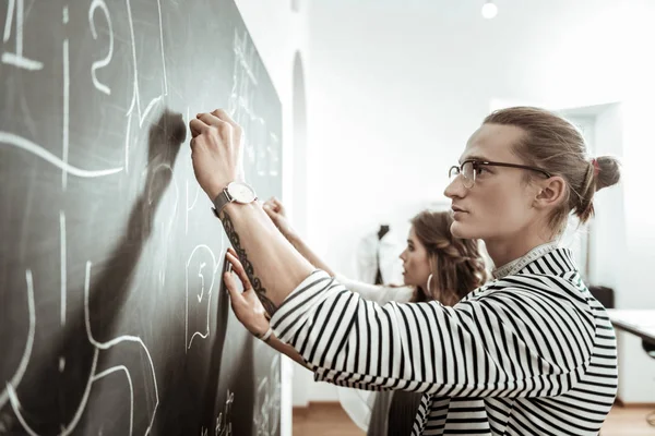 Yakışıklı genç terzi gözlük ve skeçler bir tahtada çizim güzel bir model
