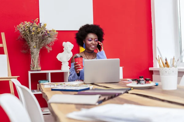 Créateur de mode tenant tasse rouge de latte tout en parlant par téléphone — Photo