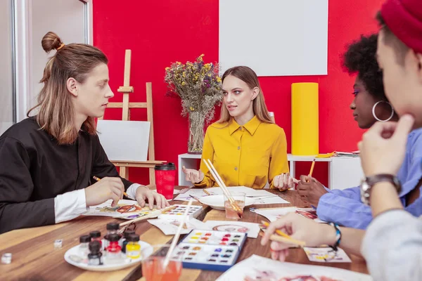 Cuatro prometedores jóvenes estudiantes de arte teniendo una lluvia de ideas — Foto de Stock