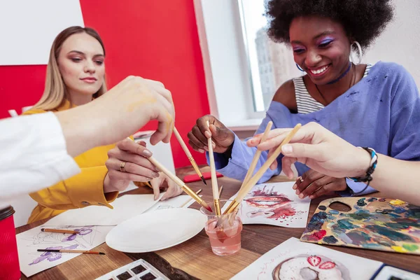 Alegre sorrindo estudantes de arte desenho usando pincéis de pintura — Fotografia de Stock