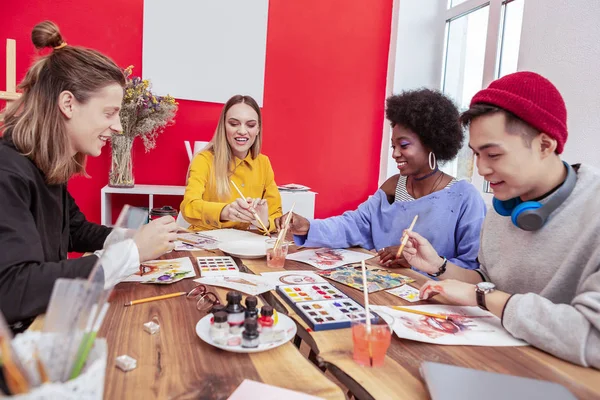 Vier Kunststudenten fühlen sich in Gruppenarbeit eingebunden — Stockfoto