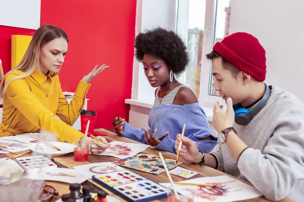 Three art students having some arguments while working together — Stock Photo, Image