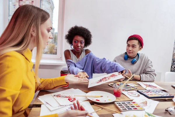 Elegante joven estudiante mostrando su resultado a la famosa joven artista — Foto de Stock