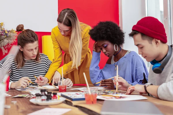 Bra lärare hjälpa hennes konst studenter håller på arbete — Stockfoto