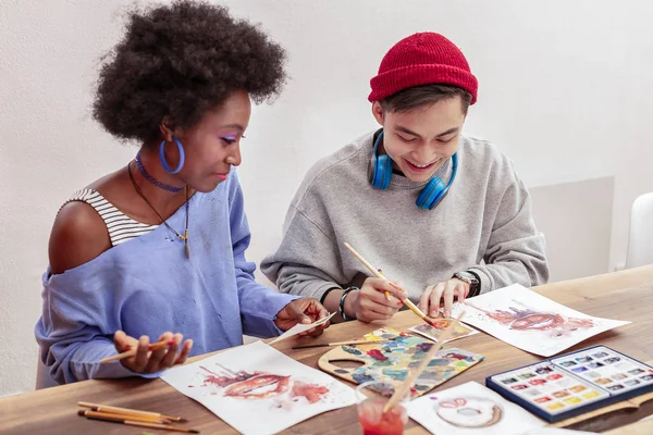 Pareja de estudiantes de arte mezclando colores mientras dibujan juntos — Foto de Stock