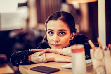 Çekici esmer kadın doğrudan kameraya bakıyor.