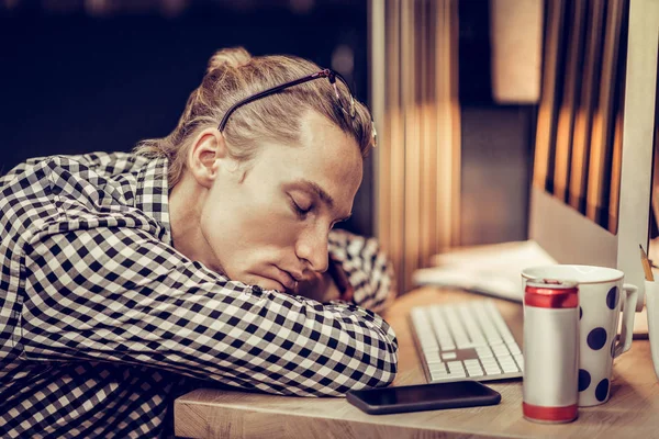 Jovem cansado deitado em seu local de trabalho — Fotografia de Stock