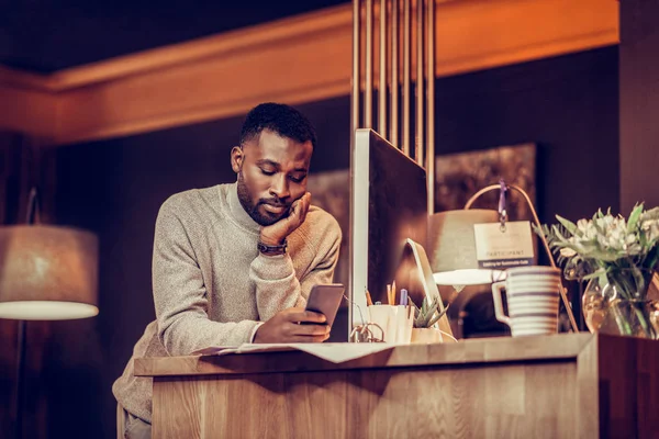 Aburrido hombre internacional leyendo el mensaje por teléfono — Foto de Stock