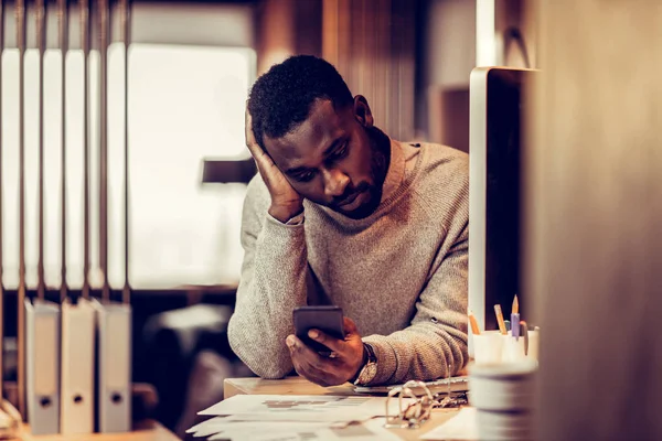 Attentif jeune homme regardant l'écran de son gadget — Photo