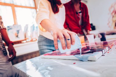 Kot pantolon ve ana sınıfı veren bej gömlek giyen kızıl saçlı sanatçı