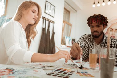 Sanat öğrencileri üniversite proje üzerinde çalışırken suluboya kullanarak