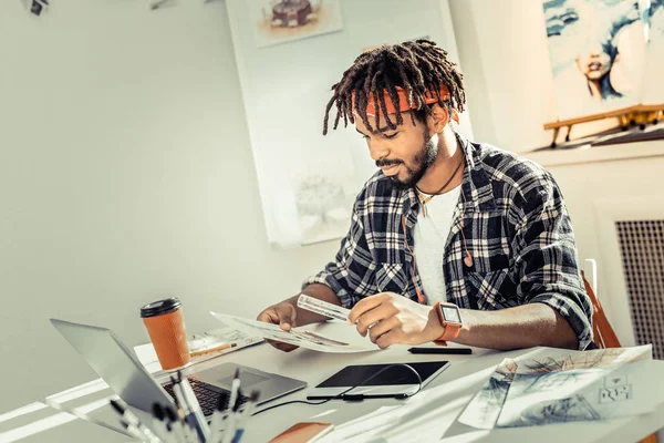 Γενειοφόρος εσωτερικό σχεδιαστή με dreadlocks κρατώντας χάρακα στο χέρι — Φωτογραφία Αρχείου