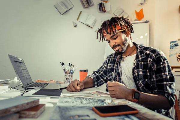 Skäggiga mörkhårig konstnär med dreadlocks innehar penna — Stockfoto