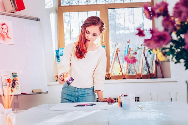 Artista joven pelirroja sintiéndose involucrado en la pintura de mármol — Foto de Stock