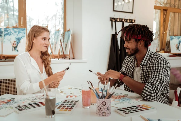 Artistas sentados a la mesa con acuarela y pinceles — Foto de Stock