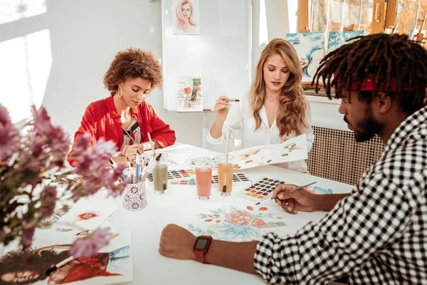 Equipo de tres jóvenes artistas prometedores dibujando todos juntos — Foto de Stock