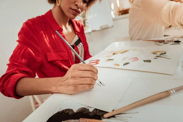 Mujer talentosa con blusa roja sosteniendo pincel de pintura — Foto de Stock