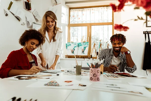 Dos estudiantes de arte radiantes y alegres escuchando a su maestro — Foto de Stock