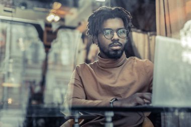 Ciddi esmer genç erkek onun aygıtı ile çalışma