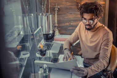 Ciddi sakallı erkek kişi onun notlara bakarak