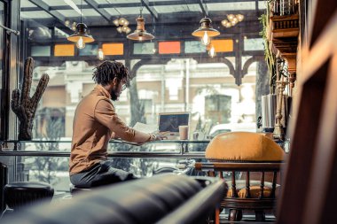 Özenli genç adam bilgisayar ekranına bakıyor.