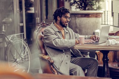 Olumlu memnun esmer adam onun bilgisayar çalışma