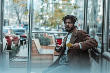 Müzik app. özenli erkek otobüs beklerken dört gözle