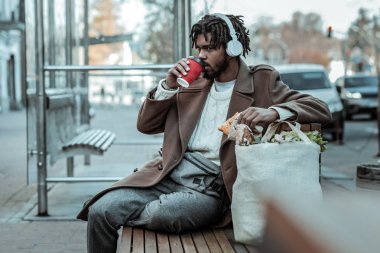 Ciddi genç adam onun sıcak kahve keyfi