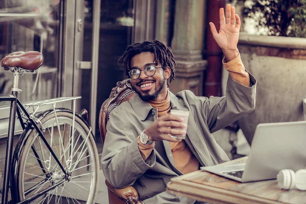 Handsome international male person waving his hand