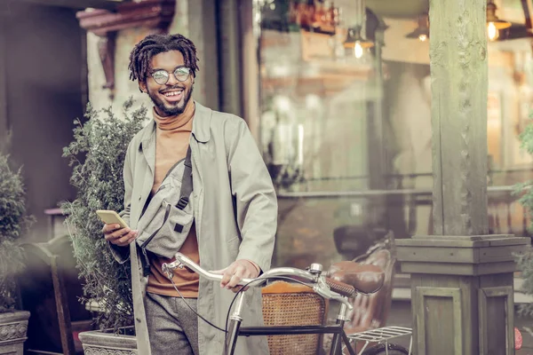 Positieve blij man die in de buurt van zijn fiets — Stockfoto