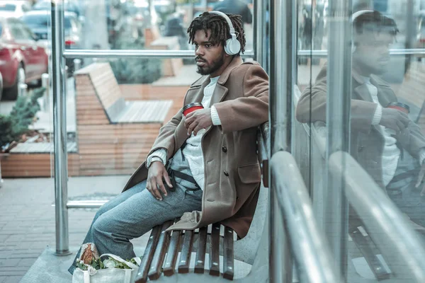 Homme sérieux assis en position semi sur le banc — Photo