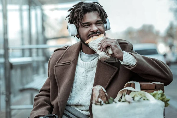 Étkezési finom péksütemények éhes fiatal férfi — Stock Fotó
