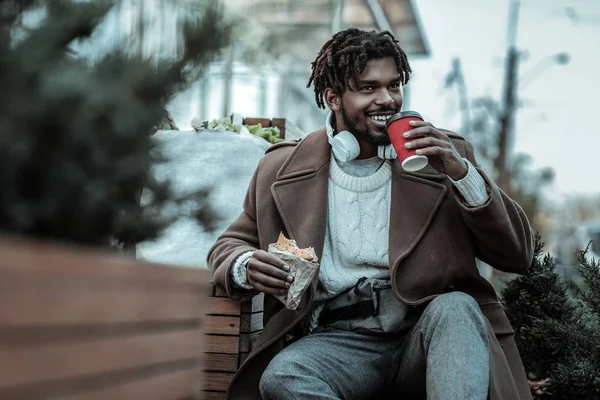 Positivo encantado persona masculina comiendo pastelería sabrosa — Foto de Stock