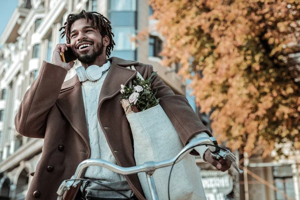 Telefon başına konuşan mutlu bir erkek.