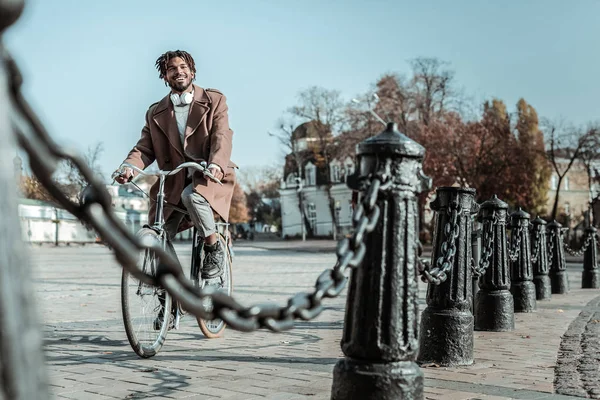 Веселый международный фрилансер на велосипеде по площади — стоковое фото