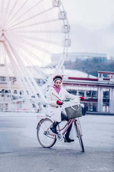 Neşeli esmer kadın kameraya bakıyor.