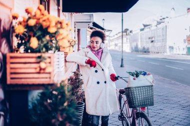 Dükkanı penceresine bakarak özenli esmer kadın