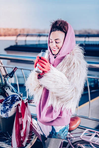 Chica encantada positiva mirando su taza termo —  Fotos de Stock